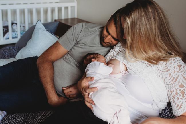 Perth-Newborn-Photographer-46-of-60 Mother breastfeeding as father rests next to them with Perth newborn lifestyle photographer