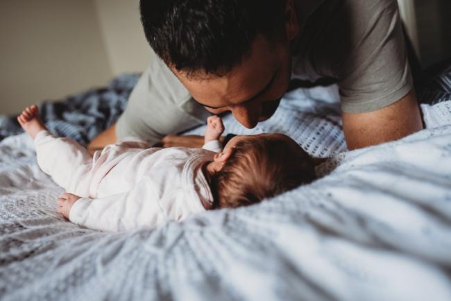 Perth-Newborn-Photographer-51-of-60 Father leaning in to kiss his newborn baby with Perth newborn lifestyle photographer