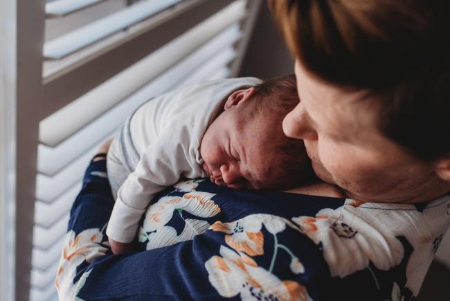 Baby sleeping on mother's chest with Perth newborn lifestyle photographer