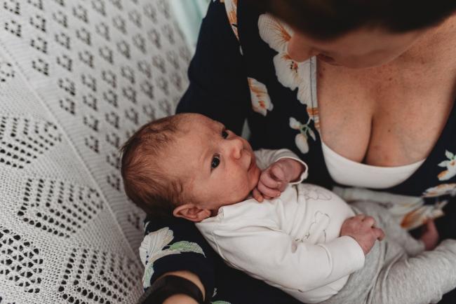 Newborn baby in mother's arms with Perth newborn lifestyle photographer
