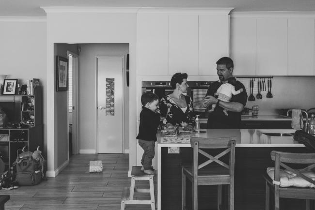 black and white image of family in the kitchen with Perth newborn lifestyle photographer