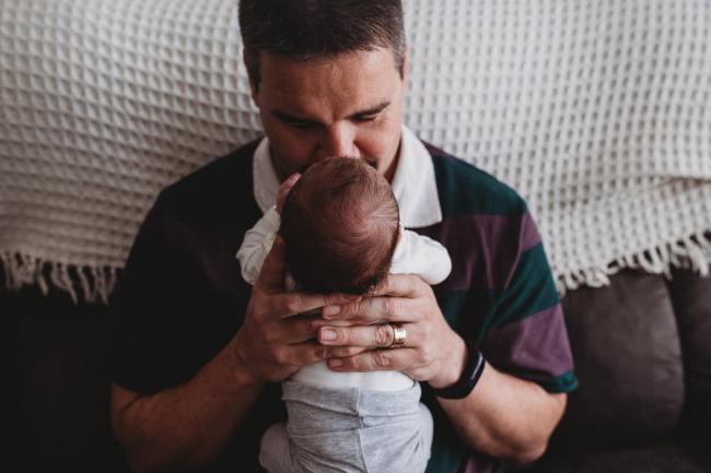 Father holding newborn baby to his face with Perth newborn lifestyle photographer