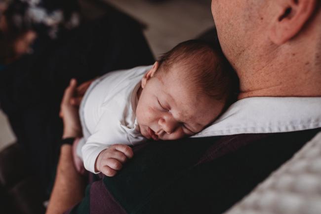 newborn baby sleeping on father's chest with Perth newborn lifestyle photographer
