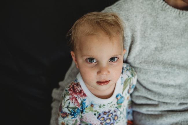 Little girl looking up at camera with family photographer Perth