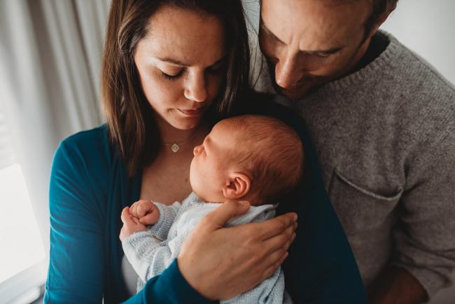 Parents holding newborn baby with lifestyle newborn photographer Perth
