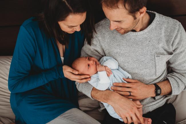 Parents holding new baby with lifestyle newborn photographer Perth