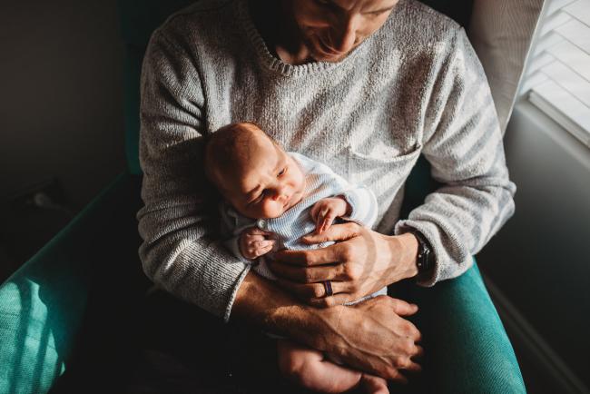 Father holding newborn baby with lifestyle newborn photographer Perth