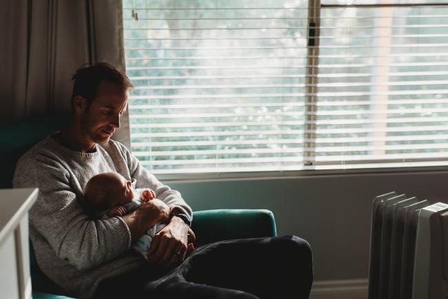 Father on chair with newborn baby with lifestyle newborn photographer Perth
