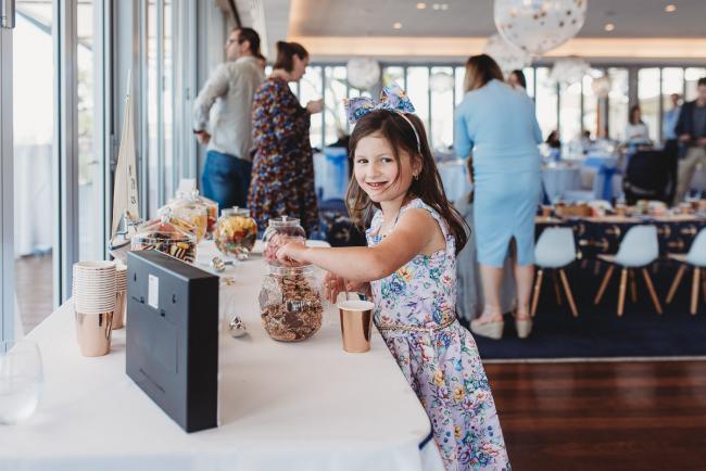 Little girl reaching for lollies at the lolly table during first birthday party with Perth Events Photographer
