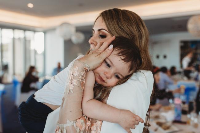 Little boy cuddling into his mother during first birthday party with Perth Events Photographer