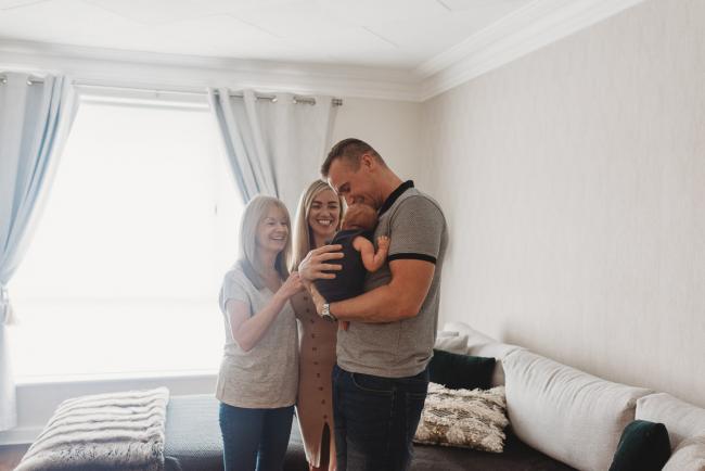 Lifestyle-Newborn-Photographer-Perth-10-of-69 Mother, father and grandmother standing in lounge room with newborn baby with in-home lifestyle newborn photographer Perth