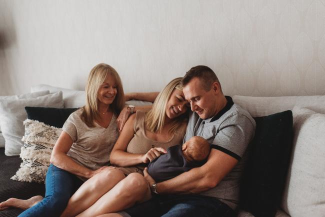 Lifestyle-Newborn-Photographer-Perth-13-of-69 Mother, father and grandmother sitting on couch with newborn baby with in-home lifestyle newborn photographer Perth