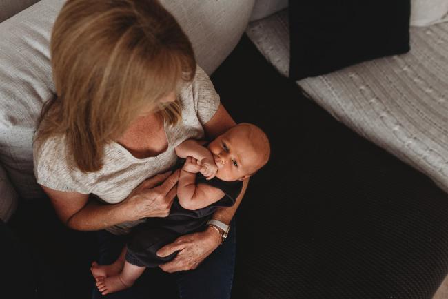 Lifestyle-Newborn-Photographer-Perth-16-of-69 Grandmother holding newborn baby grandson on couch with in-home lifestyle newborn photographer Perth