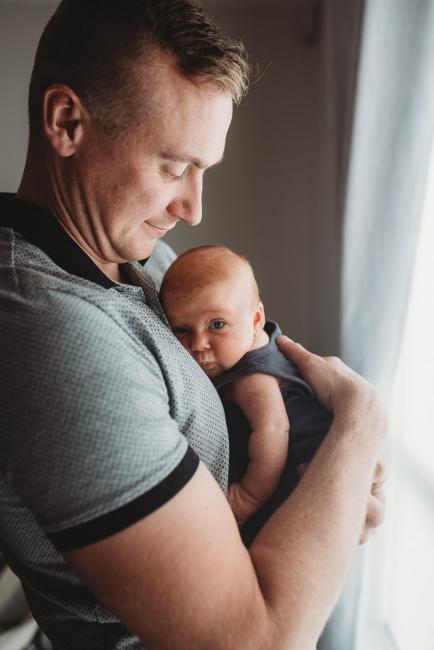 Lifestyle-Newborn-Photographer-Perth-28-of-69 Father holding newborn baby against his chest with in-home lifestyle newborn photographer Perth