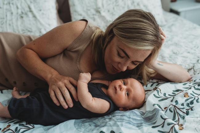 Lifestyle-Newborn-Photographer-Perth-35-of-69 Mother laying next to newborn baby on bed with in-home lifestyle newborn photographer Perth