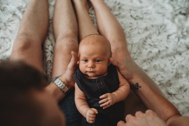 Lifestyle-Newborn-Photographer-Perth-39-of-69 Newborn baby laying on parents laps with in-home lifestyle newborn photographer Perth