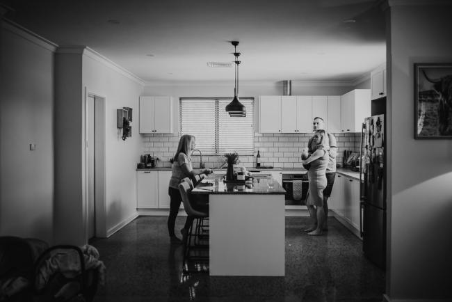 Lifestyle-Newborn-Photographer-Perth-42-of-69 Black and white image of grandmother, father and mother in kitchen with newborn baby with in-home lifestyle newborn photographer Perth