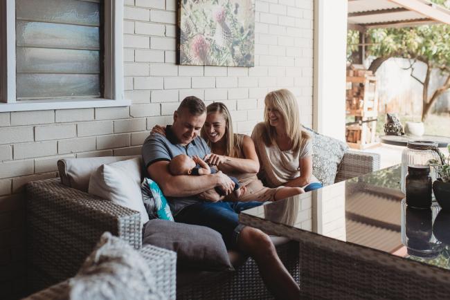 Lifestyle-Newborn-Photographer-Perth-49-of-69 Mother, father and grandmother sitting on couch outside with newborn baby with Perth lifestyle newborn photographer