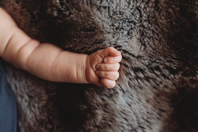 Close up on newborn baby fist with lifestyle newborn photographer Perth