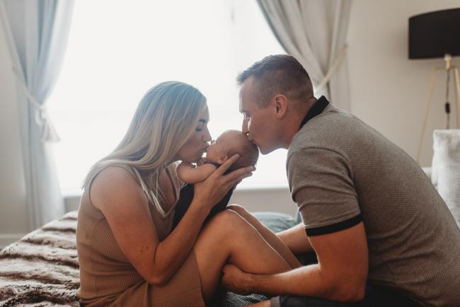 Lifestyle-Newborn-Photographer-Perth-62-of-69 Parents kissing newborn baby in front of window with Perth lifestyle newborn photographer