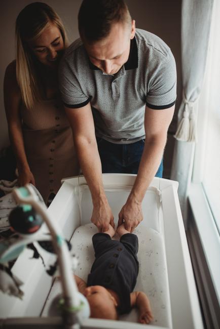 Lifestyle-Newborn-Photographer-Perth-65-of-69 Parents looking down at newborn baby in bassinet with Perth lifestyle newborn photographer
