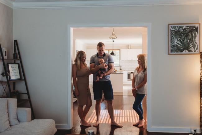 Lifestyle-Newborn-Photographer-Perth-68-of-69 Mother, father and grandmother standing in lounge room door way with newborn baby with in-home lifestyle newborn photographer Perth