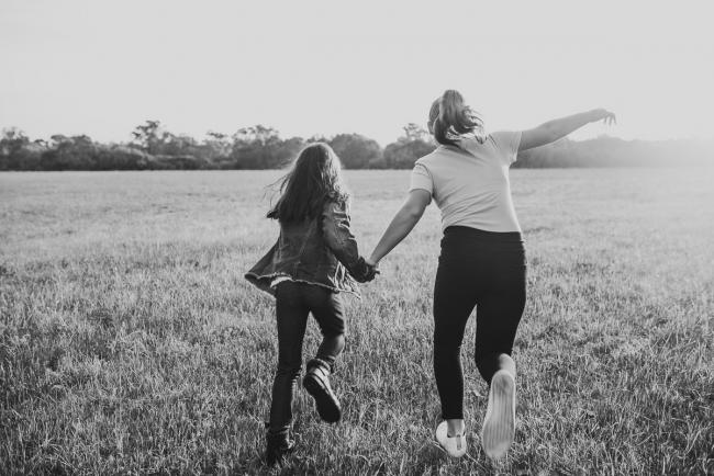 Black and white image of sisters running during Perth family photographer session at Perry's Paddock