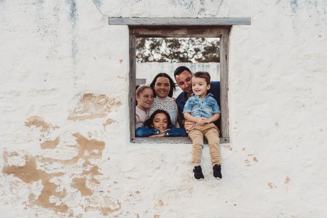 Family looking through a window during Perth family photographer session at Perry's Paddock