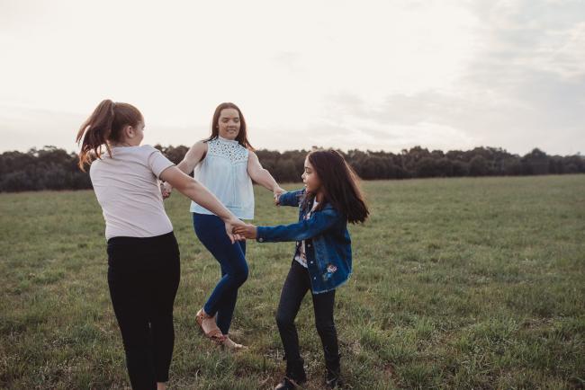 Mother and daughters playing ring-a-rosy during Perth family photographer session at Perry's Paddock