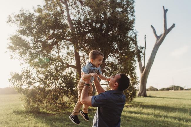 Father lifting son in the air during Perth family photographer session at Perry's Paddock