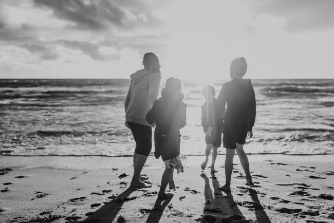 Family-Photographer-Perth-Burns-Beach-10-of-57 Black and white image of siblings running towards water at Burns Beach with Perth Family Photographer