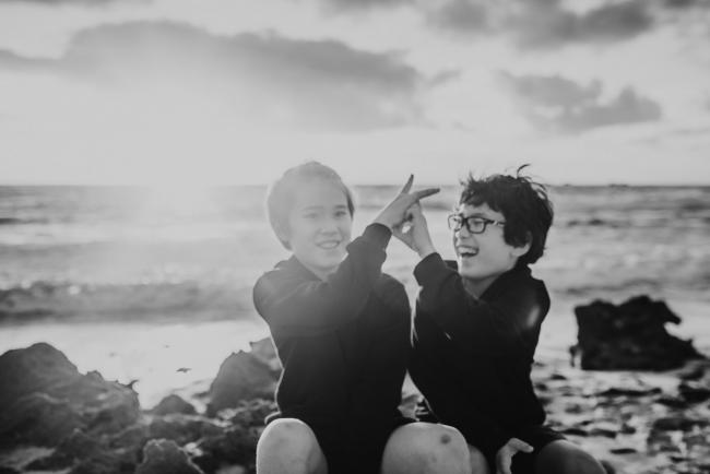 Black and white image of brothers playing at Burns Beach with Perth Family Photographer