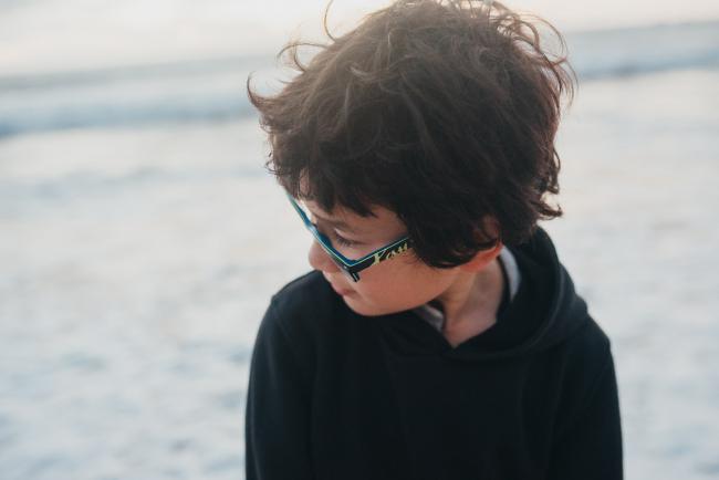 little boy looking down at Burns Beach with Perth Family Photographer