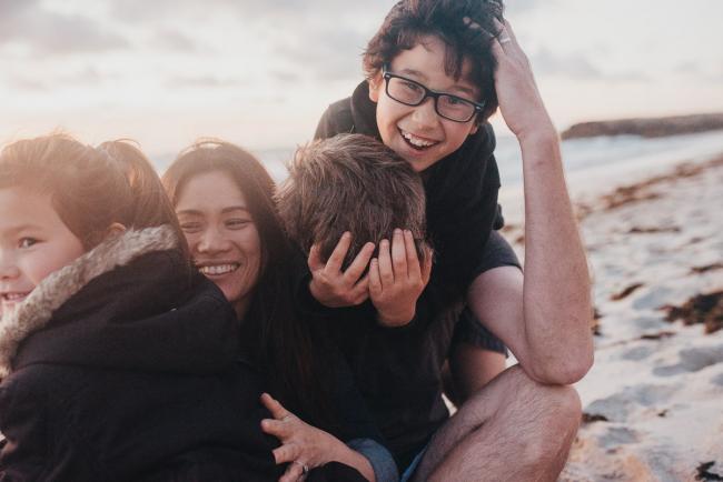 Family-Photographer-Perth-Burns-Beach-57-of-57 Kids piling on top of parents at Burns Beach with Perth Family Photographer
