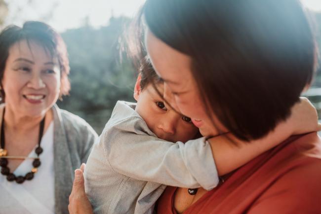 Family-Photographer-Perth-Hyde-Park-10-of-54 Son hugging mother as grandmother looks on and smiles during Perth extended family session at Hyde Park with Perth family photographer