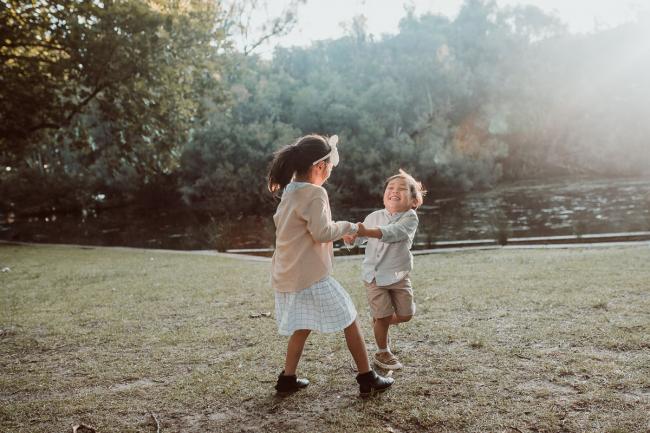 Family-Photographer-Perth-Hyde-Park-16-of-54 Brother and sister holding hands and spinning during Perth extended family session at Hyde Park with Perth family photographer