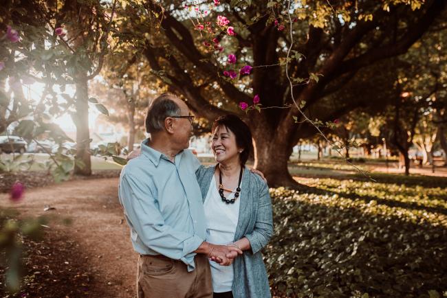 Family-Photographer-Perth-Hyde-Park-18-of-54 Couple smile at each other under tree during Perth extended family session at Hyde Park with Perth family photographer