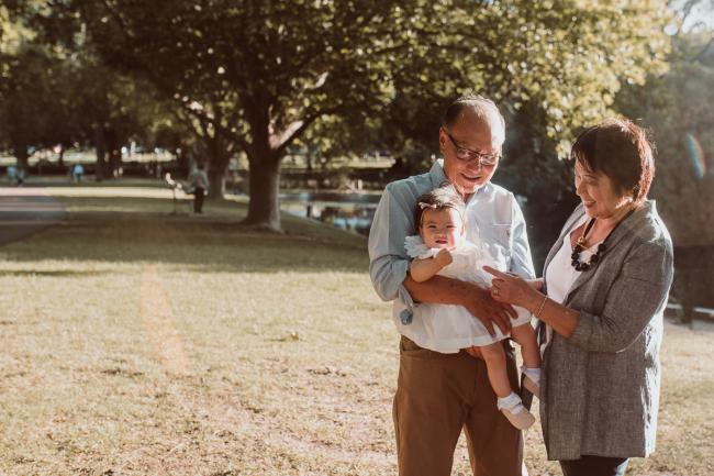 Family-Photographer-Perth-Hyde-Park-3-of-54 Grandparents holding baby granddaughter during Perth extended family session at Hyde Park with Perth family photographer