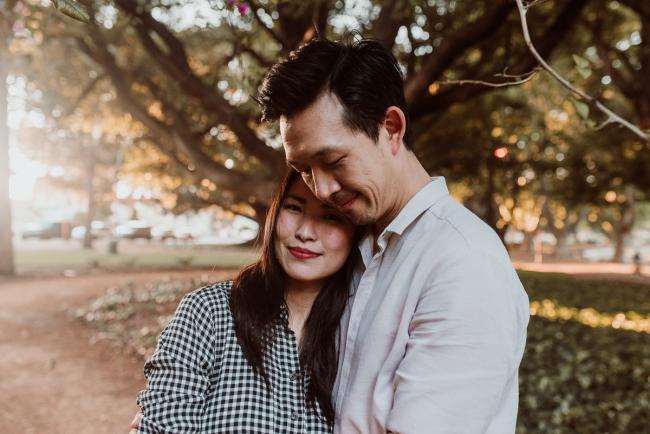 Wife resting head on husbands chest during Perth extended family session at Hyde Park with Perth family photographer