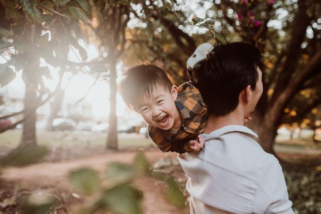 Family-Photographer-Perth-Hyde-Park-37-of-54 Boy laughing over father's shoulder during Perth extended family session at Hyde Park with Perth family photographer