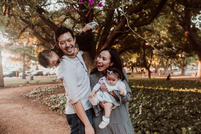 Father holding son over shoulder as mother holds daughter during Perth extended family session at Hyde Park with Perth family photographer
