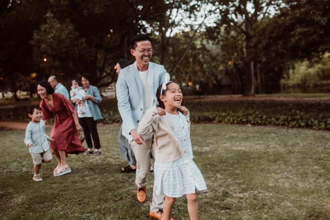 Father chasing daughter during Perth extended family session at Hyde Park with Perth family photographer