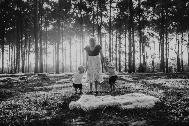 Family-Photographer-Perth-The-Pines-14-of-29 black and white image of mother holding sons hands during Perth family photography session at The Pines Wanneroo