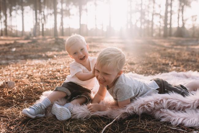 Family-Photographer-Perth-The-Pines-16-of-29 One brother pushing another brother during Perth family photography session at The Pines Wanneroo
