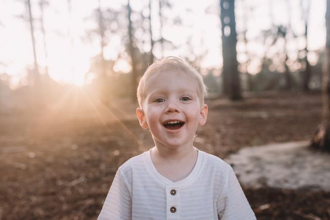 Family-Photographer-Perth-The-Pines-29-of-29 boy smiling at camera during Perth family photography session at The Pines Wanneroo
