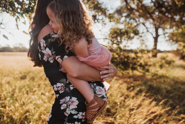 Pregnant mother holding daughter during Perth maternity photography session during golden hour at Perry's Paddock