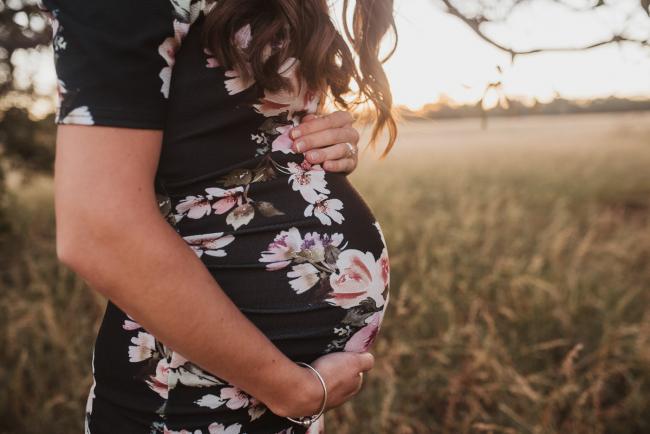 Close up of pregnant tummy during Perth maternity photography session during golden hour at Perry's Paddock