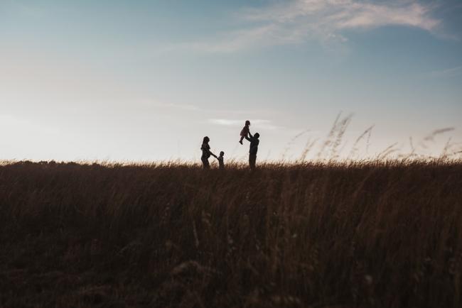 Silhouette of pregnant mother with her two kids and husband during Perth maternity photography session during golden hour at Perry's Paddock
