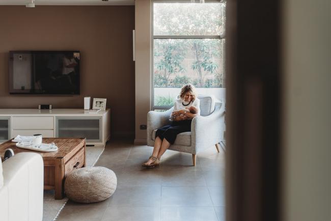 Newborn-Lifestyle-Photographer-Perth-20-of-50 grandmother holding newborn baby on chair during Perth lifestyle newborn photography session