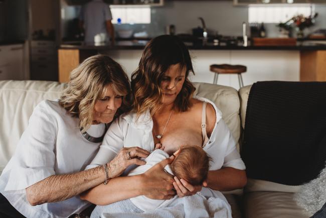 Newborn-Lifestyle-Photographer-Perth-22-of-50 Mother breastfeeding newborn baby on couch with grandmother cuddling into them during Perth lifestyle newborn photography session